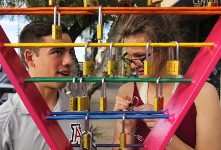 UA sophomores Andrea Gauthier and Luis Rosano decide where to hang their locks to celebrate the year and a half that they have been together on Feb. 11 during the Fourth Avenue Lock your Love event. The event benefits different nonprofits in town.