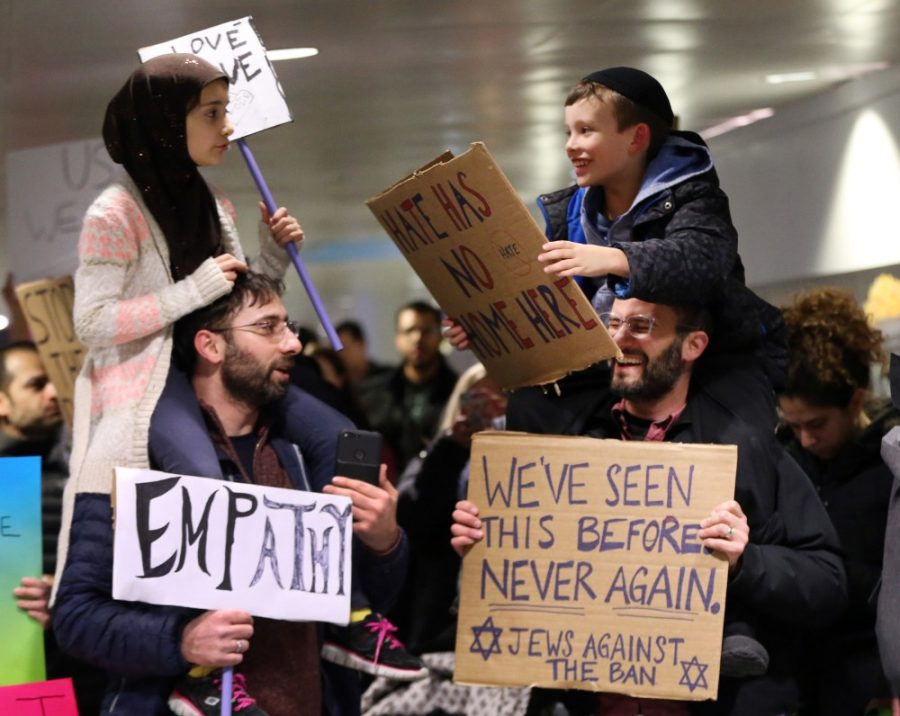 Meryem Yildirim, 7, left, sits on her father, Fatim, of Schaumburg, and Adin Bendat-Appell, 9, right, sits on his father, Rabbi Jordan Bendat-Appell, of Deerfield, during a protest on Monday, Jan. 30, 2017 at OHare International Airport in Chicago, Ill. (Nuccio DiNuzzo/Chicago Tribune/TNS)