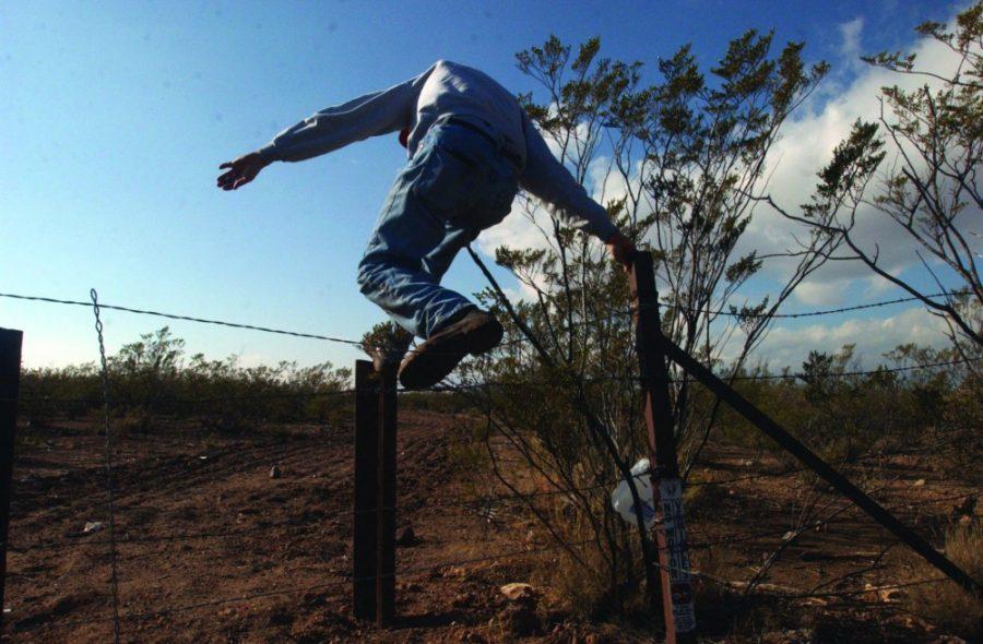 Chris Simcox, leader of the Civil Homeland Defense and publisher of the Tombstone Tumbleweed in Tombstone, Arizona, leaps over a fence made with railroad rails to stop vehicles from driving on this public land near the USA-Mexico border on Friday Jan. 23, 2004. Simcox leads a group of volunteers who patrol the US-Mexico border for illegal immigrants. Simcox has spots that he and his group monitor several times a week. Photo by Max Becherer 1/23/04                                