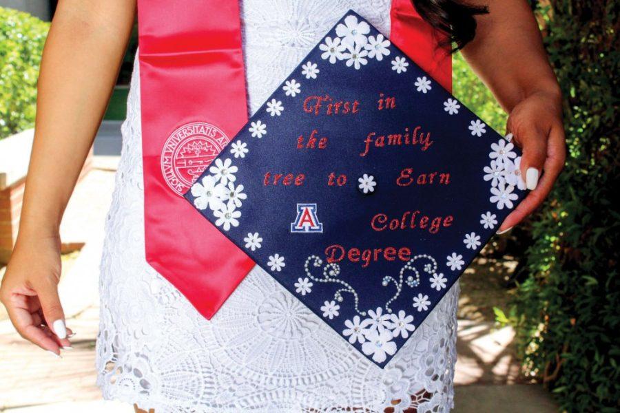 Celes Mora displays her cap that’s a statement to her commitment to getting a college education by the rose garden on the east side of the Forbes Building on April 16. Mora is the first to be a college graduate, and hopes she won’t be the last, in her family.