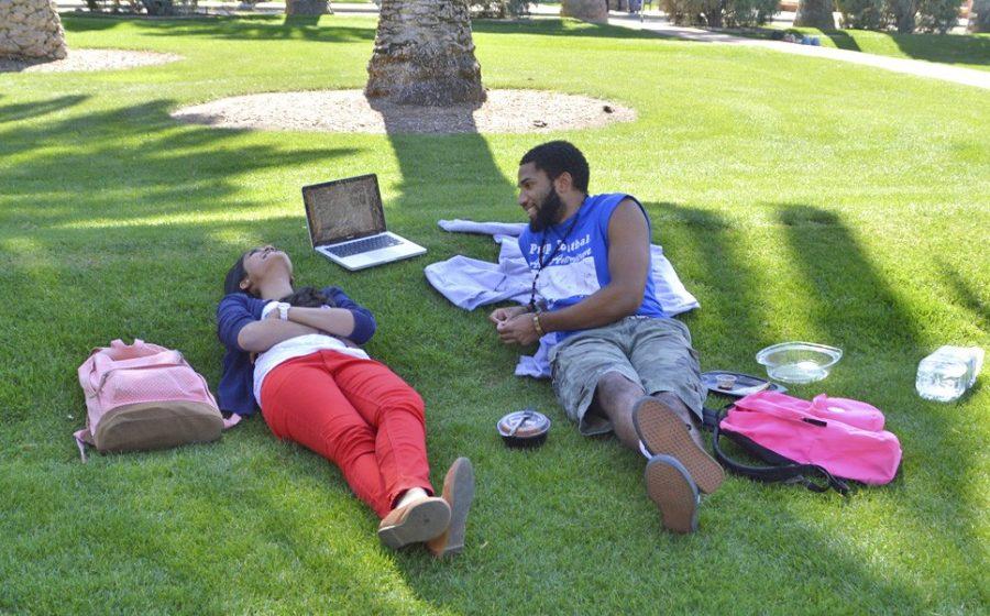 Physiology major Aishwarya Karlapudi, left, and business and management major Winkfield Twyman, right, spend their afternoon sitting on the grass outside the Arizona State Museum. Summer provides the ideal time — and maybe the only sufficient amount of time — for students to relax.