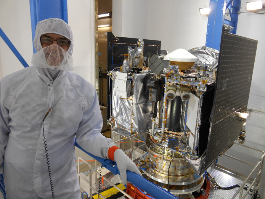Mission Principal Investigator Dante Lauretta poses in front of the OSIRIS-REx spacecraft during its construction at Lockheed Martin Space Systems in Littleton, Colo. OSIRIS-REx will investigate and collect samples from the near-Earth asteroid Bennu.
