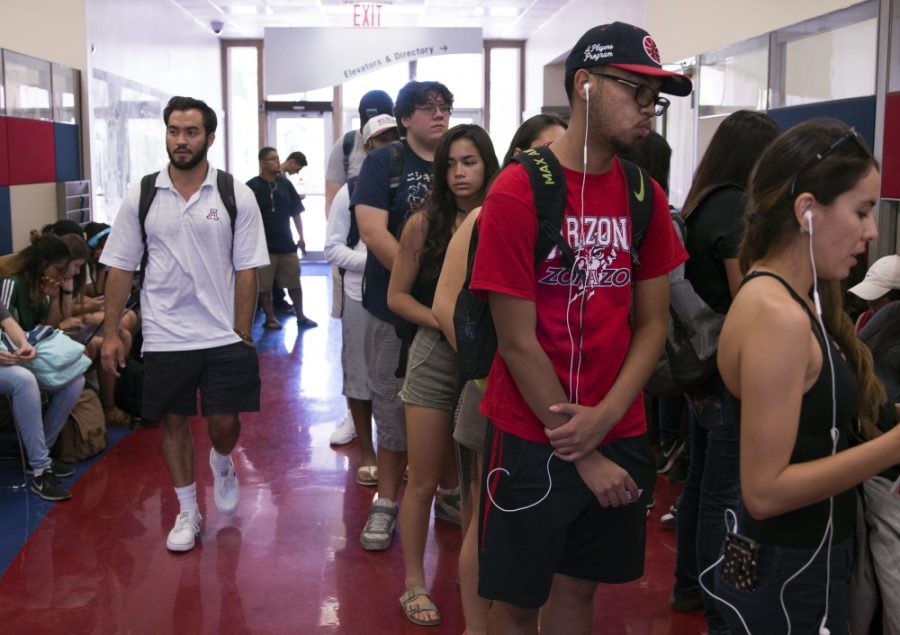 Students wait in line to receive a ticket number before being assisted at the office of scholarships and financial aid on the first day of school, Aug. 21.