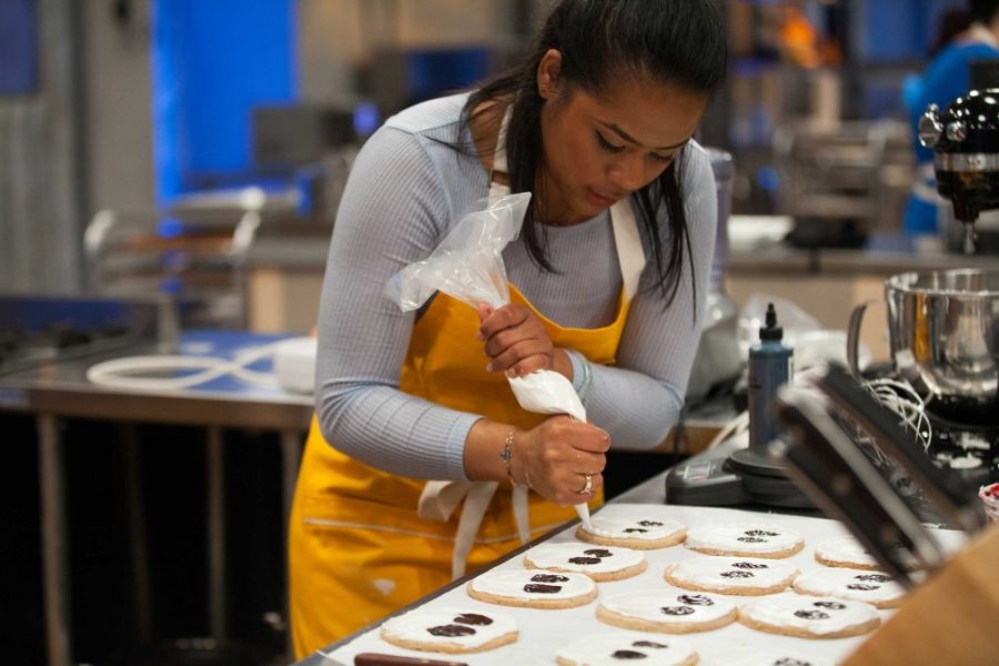 Baker Jasmin Bell rushes to finish decorating Halloween cookies on Food Networks Halloween Baking Championship. Bell is an alumna of the University of Arizona.