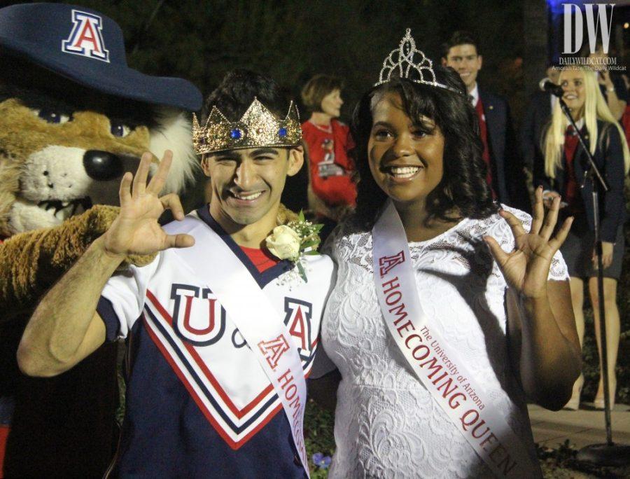 Yezan Hassan, left, and Kiana Adams-Baker, right, pose and hold up the bear down sign after winning homecoming king and queen at the 2017 University of Arizona bonfire on Oct. 27.

