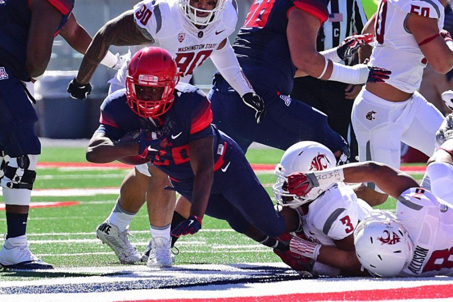 Arizona running back Nick Wilson (28) gets tackled by Washington State players at Arizona Stadium during the Wildcats 42-45 loss on Oct. 24, 2015. With a win on Saturday, the Wildcats would be bowl-eligible after missing out on post-season the year prior.