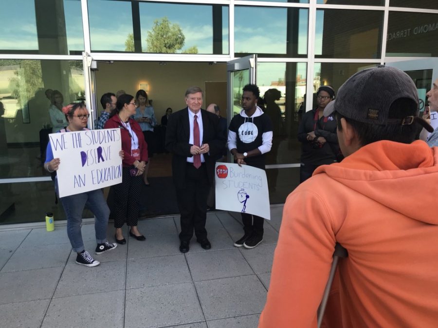Arizona Board of Regents chair Bill Ridenour speaks to student protestors outside the regents meeting on Friday Nov. 17. 