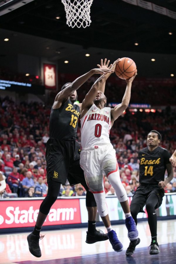 Arizonas Parker Jackson-Cartwright (0) tries to muscle past a Long Beach States Barry Ogalue (13) for a layup during the UA-LBSU game. At the half, Jackson-Cartwright had 8 points, making three of three shots.