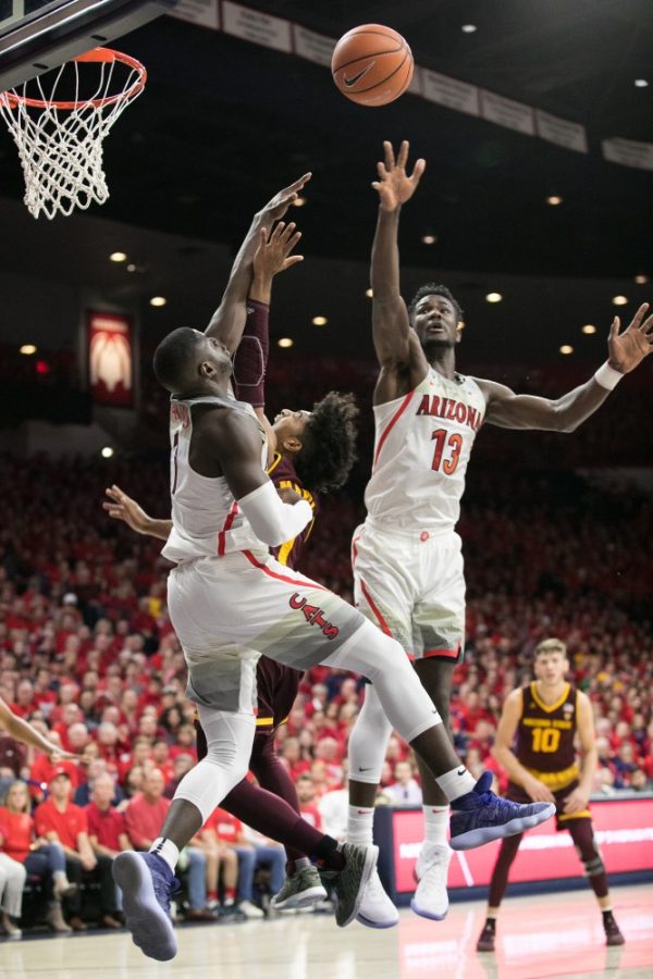 Arizonas Rawle Alkins, left, and Deandre Ayton, right, jump to block a shot by Arizona States Remy Martin, center. The Wildcats beat the Sun Devils 84-78.
