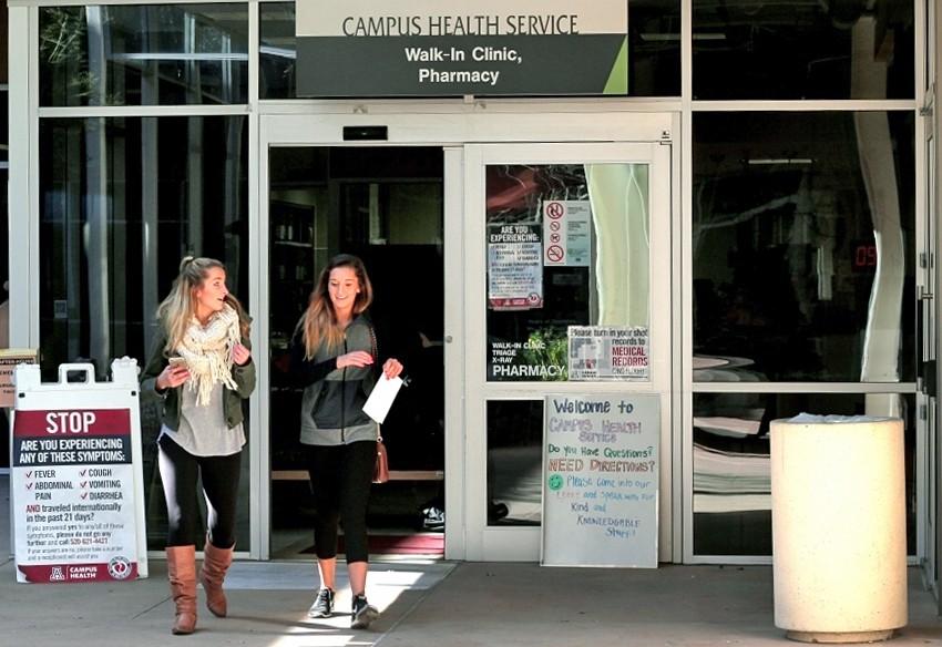 Kiersten Kunkle, left, and Macie Andrews, right, walk out of the Campus Health Center on Feb. 5, 2016.