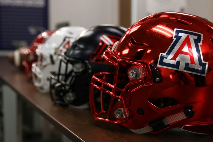 University of Arizona football helmets sit in a row before the start of the press conference to introduce head football coach, Kevin Sumlin. 