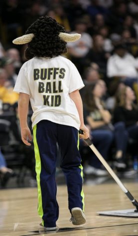 A "Buff Ball Boy" sweeps the court, showing off his local pride.