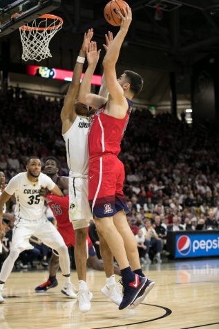 Met with heavy Colorado defense, Arizona's Dusan Ristic, right, hooks the ball in during the second half.