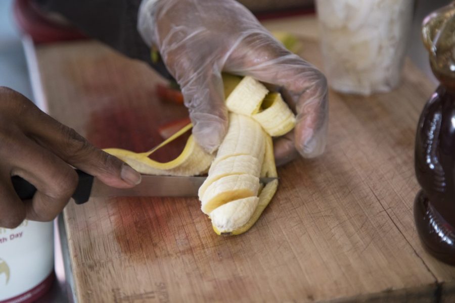 André Newman cuts a banana that will be put into a fresh açaí bowl.