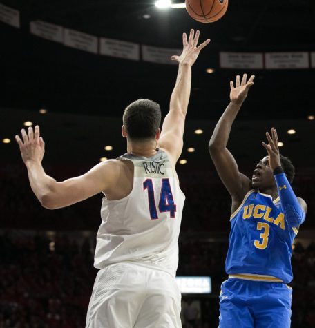 UCLA's Aaron Holiday (3) floats the ball over Arizona's Dusan Ristic (14) during the  UA-UCLA game on Thursday, Feb. 8 at McKale Center in Tucson, Ariz.