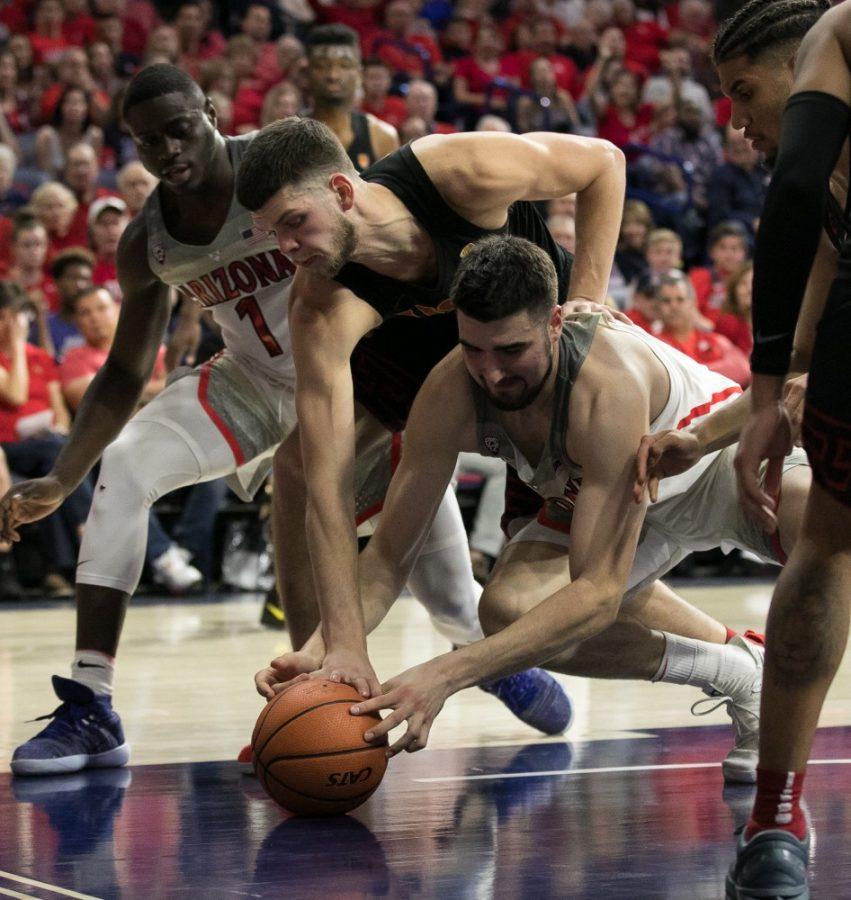 Arizonas Dusan Ristic, below, and USCs Nick Rakocevic, above, fight for the ball during the second half of the UA-USC game on Saturday, Feb. 10 at McKale Center in Tucson, Ariz.