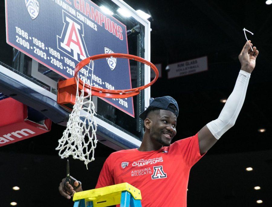 Then Arizona freshman Deandre Ayton cuts down a piece of the net after clinching the Pac-12 regular season title after the Arizona-Cal game on Saturday, March 3, 2018, in McKale Center.