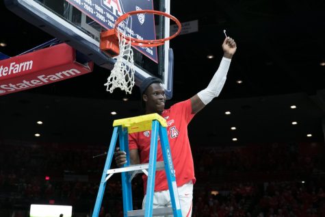 Arizona's Emmanuel Akot cuts down a piece of the net after the Arizona-Cal game on Saturday, March 3 in McKale Center.