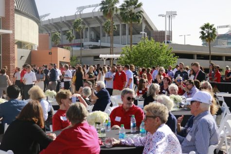 Attendees drink, eat and talk before the unveiling ceremony of the Lute Olson statue at the Eddie Lynch Athletics Pavilion on April 12.
