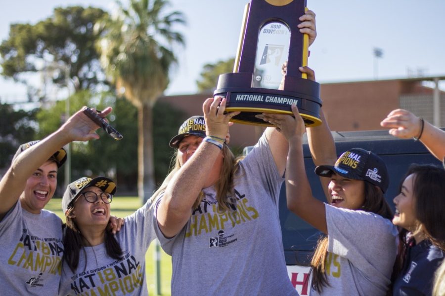 The Womens Golf Team hold up the NCAA trophy for all the fans to see moments after stepping out of their vehicles on May 24, after returning from Oklahoma.