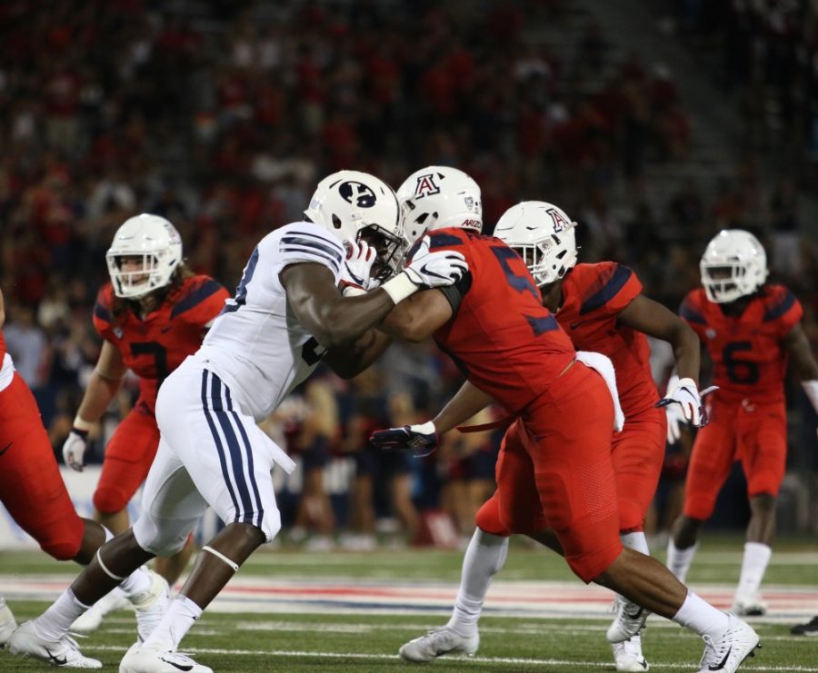 The Wildcats offensive lineman collide with BYUs defense during the 2nd half of the game. Wildcats faced off with BYU on Sep 1 at the Arizona Stadium.
