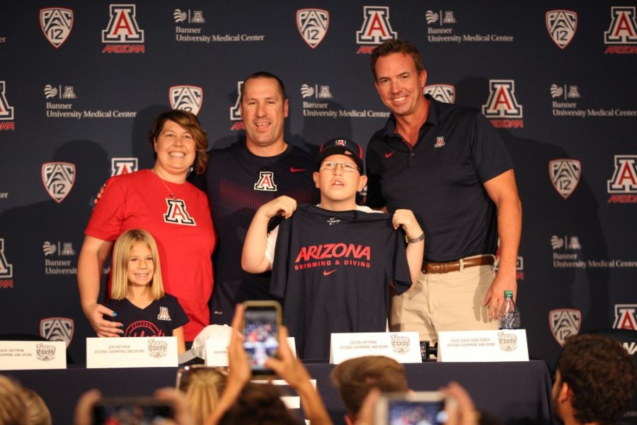 Colton+Hoffman+stands+with+his+parents%2C+Greg+and+Jen+Hoffman%2C+and+Arizona+swim+coach+Augie+Busch+at+his+signing+day+on+Sept.+28%2C+2018+at+McKale+Center.