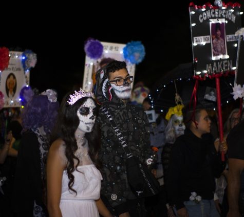 A couple makes their way down the street with other members of the All Souls Procession. The procession took place on Sunday, November 4th, and was a celebration and mourning of life.