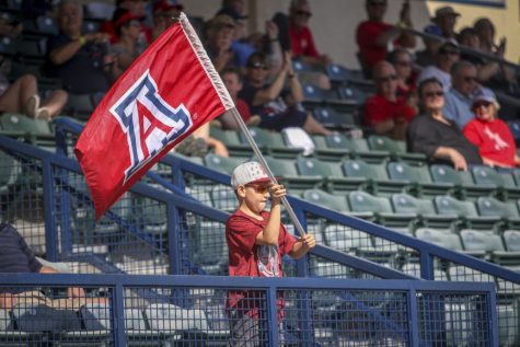 Tucson Ariz.- A little boy swinging an Arizona wildcats flag on Sunday April 14, 2019 at Hi Corbett Field. The crowd would cheer him on.