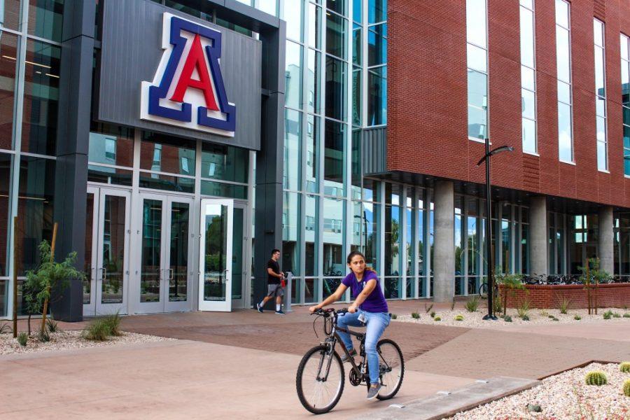 Student cycling outside the new Recreation & Wellness Center at Honors Village also known as the NorthREC.