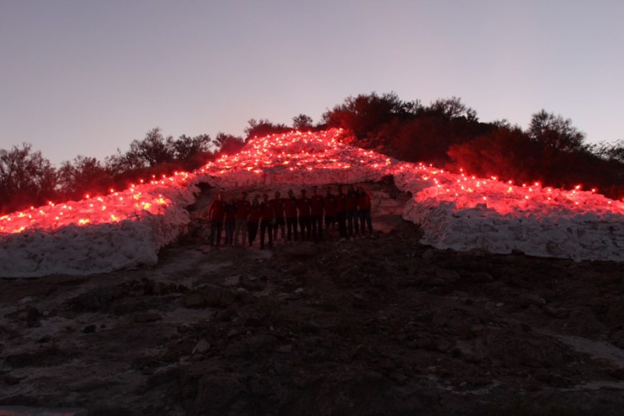 As+the+hundreds+of+flares+are+being+lit+up+the+UA+Bobcats%2C+who+take+a+moment+to+be+part+of+their+work.