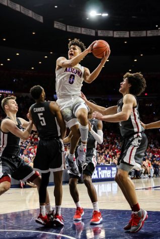 Josh Green (0) jumps past Washington State and dunks the ball into the basket.