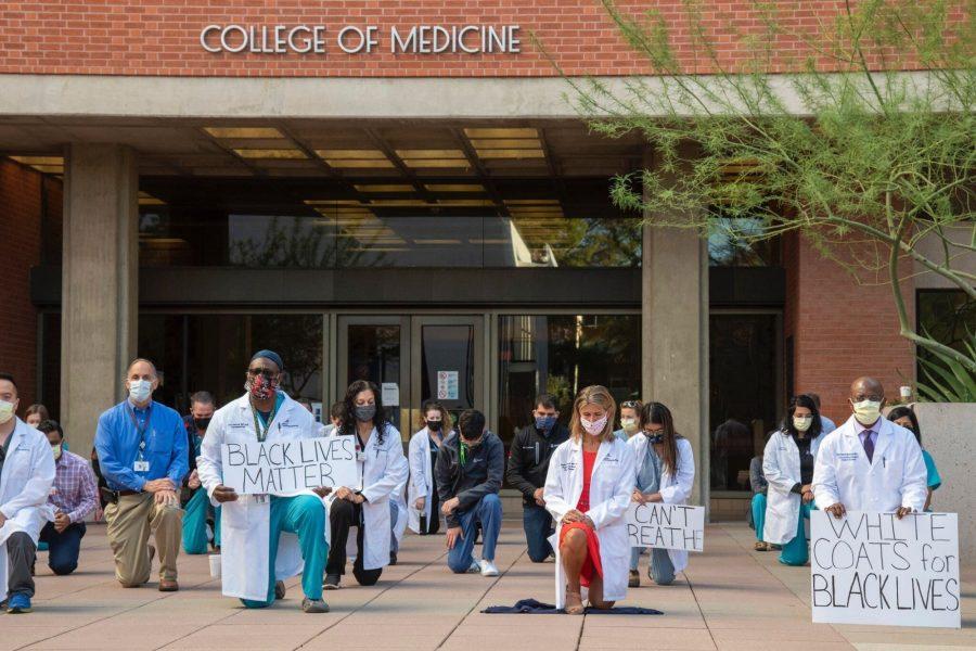 UA+healthcare+workers+and+faculty+kneeling+in+front+of+the+College+of+Medicines+building+entrance.+Courtesy+Dr.+Taylor+Riall.