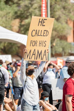 Local Tucson protestor holding up a sign with the words, "He called for his mama" written on the sign.