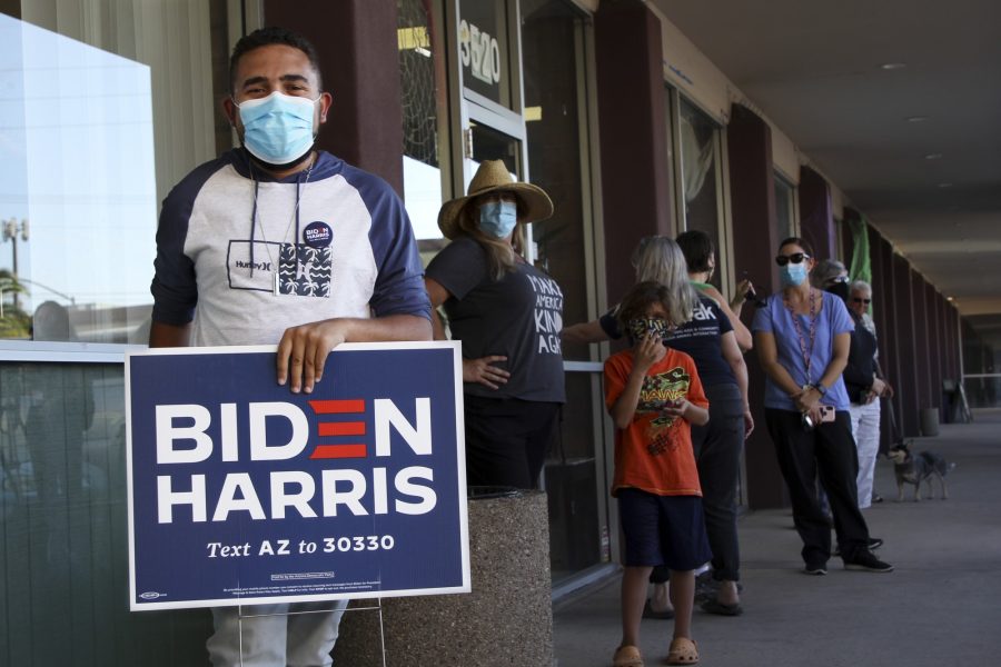 A proud Biden/Harris voter poses with a yard sign that he received at the campaign event on Friday, Oct. 9, 2020 in Tucson, Ariz.