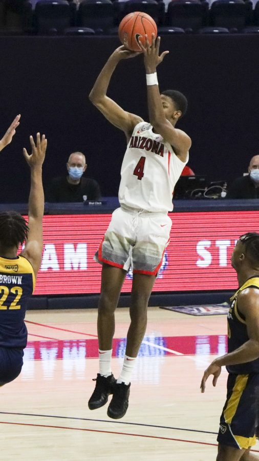 Number 4 Dalen Terry a Freshman on the University of Arizona’s Men’s basketball team takes a three-point shot over a Northern Arizona player at the McKale Memorial Center, Monday, Dec 7, 2020. The WildCats go on to win the game 96-53