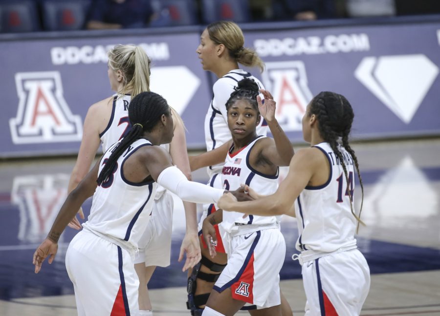 Bendu Yeaney (left), Aari McDonald (middle) and Sam Thomas (right) give each other high-fives after making a play in McKale Center in Tucson, Ariz., on Sunday, Dec. 6, 2020. (Courtesy of Mike Christy/Arizona Athletics)