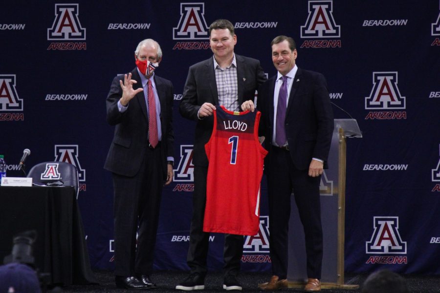 Arizona+mens+basketball+head+coach+Tommy+Lloyd+%28middle%29+holds+up+a+jersey+during+a+press+conference+standing+beside+President+Dr.+Robert+C.+Robbins+%28left%29+and+athletic+director+Dave+Heeke+%28right%29+on+Thursday%2C+April+15%2C+2021%2C+in+McKale+Center.
