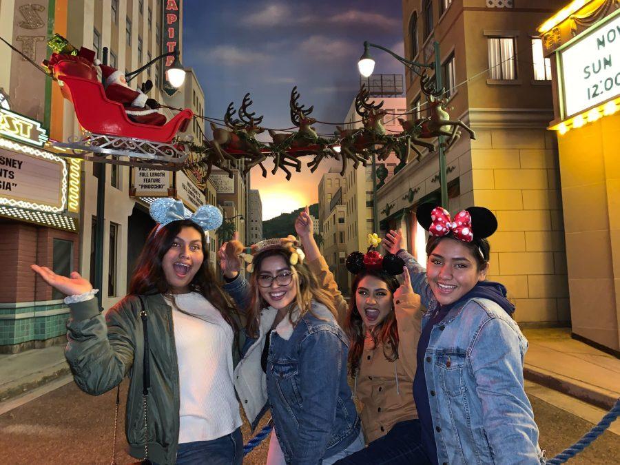 Sisters Nicole, Jacqueline, Jasmine and Roxie pose in front of a Christmas display at Disneyland.