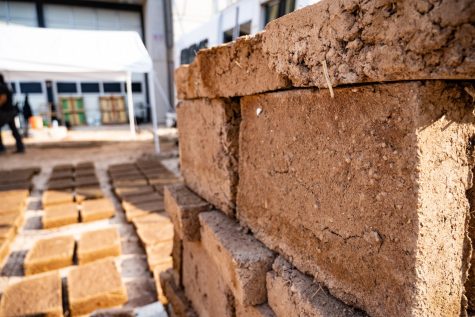 A collection of adobe bricks crafted by artists and University of Arizona students sit at the back of the Museum of Contemporary Art on Oct. 2. Finished bricks are stacked while others lie grounded, curing in the sunlight.