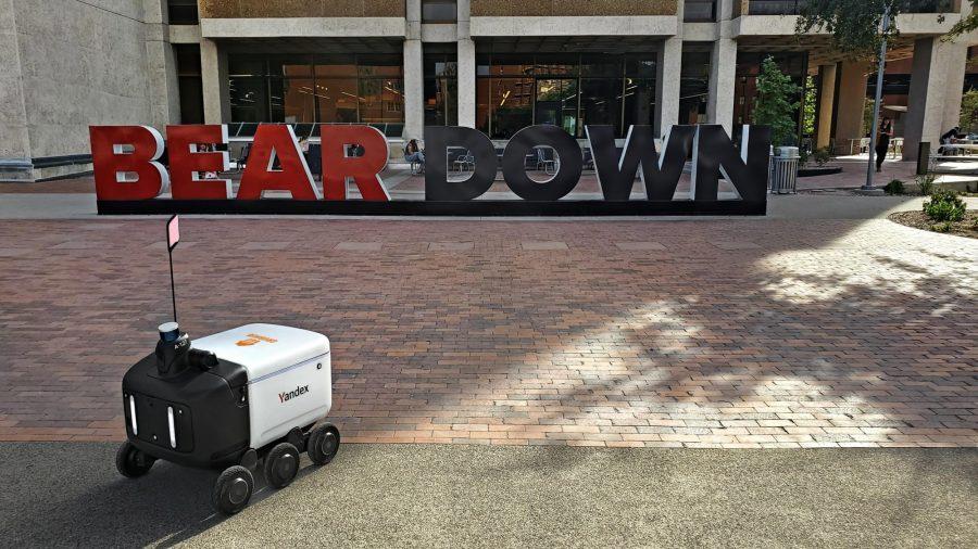 A Yandex food delivery robot sits in front of the Bear Down sign in front of the Main Library. (Photo courtesy of Yulia Shveyko.)