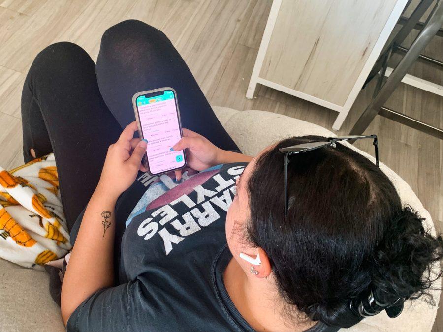 Photo Illustration: A college student scrolls through YikYak. The app was originally founded in 2013 and relaunched this year; the app allows for users to anonymously post messages to a discussion boards with nearby people.