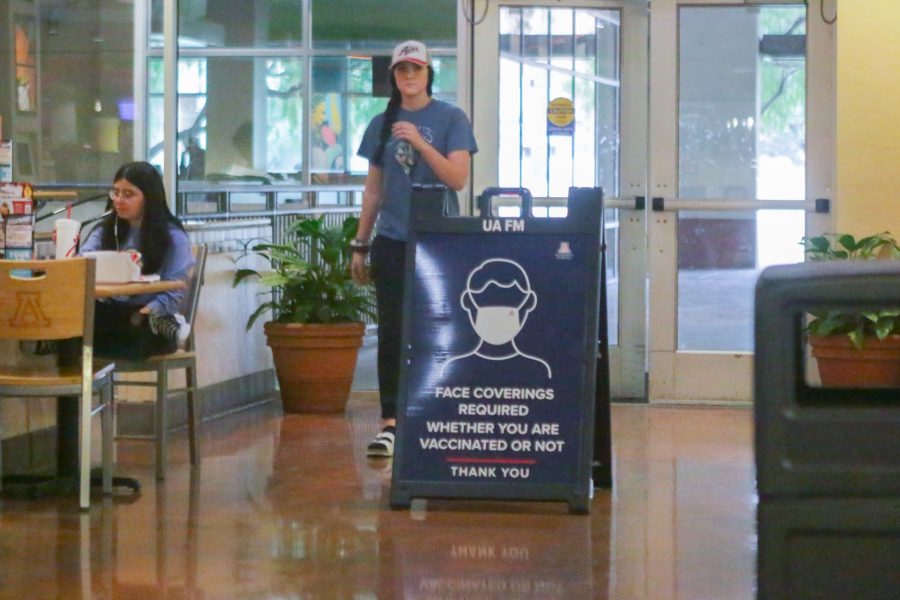 A student walks by a sign stating that masks are required inside the Student Union Memorial Centers. The rule is enforced in most indoor spaces on campus, but it doesnt always get followed.