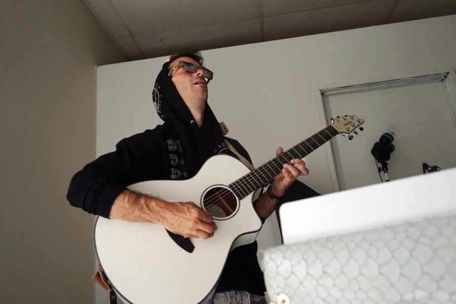 John Bollaert plays his guitar in his office space on Tues. Nov. 9, in Tucson.