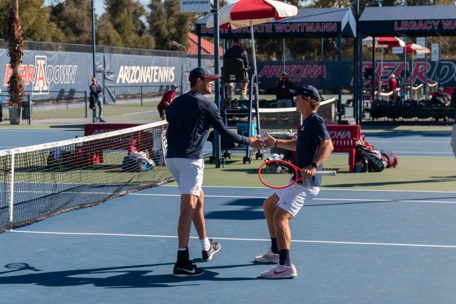 <p>Arizona men's tennis players high five after a point against New Mexico State on Feb. 6 at Lanelle Robson tennis center. Arizona lost this set 7 games to 5.</p>