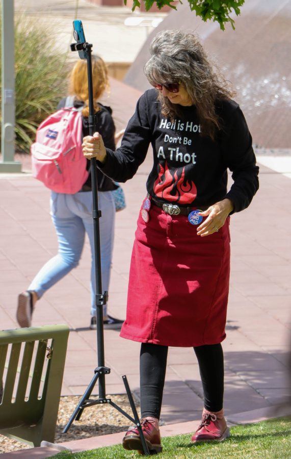 Sister Cindy, a TikTok influencer, walks her phones tripod to the grass on March 31 outside the Student Union Memorial Center. Cindy would take the stage a little after 12:45 p.m. and would start a live stream on her TikTok.