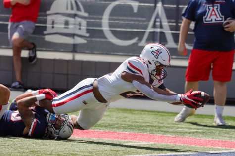 Jalen John a running back on the Arizona football team catches a pass and dives for the end-zone on April 9 at Arizona stadium. The red team (wearing white) would win the friendly game 24-21.