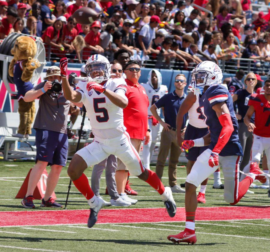 Dorian Singer, a wide receiver on the Arizona football team, tries to catch a pass on April 9 at Arizona stadium. The red team (wearing white) would win the friendly game 24-21.