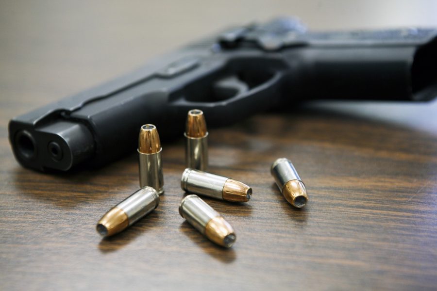 A handgun and bullets lying on a table. Gun violence by St. Louis Circuit Attorneys Office, licensed under CC BY-SA 4.0.