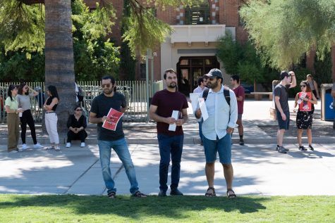 Protesters stand and talk about the poster and pamphlets they made on Sept. 30. The protest was held in front of Old Main. 