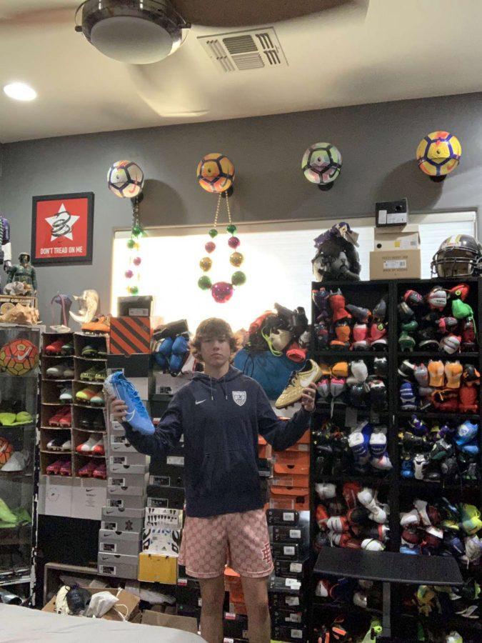 Prestley Howard stands in front of his large collection of sneakers and cleats. (Courtesy of El Inde Arizona)
